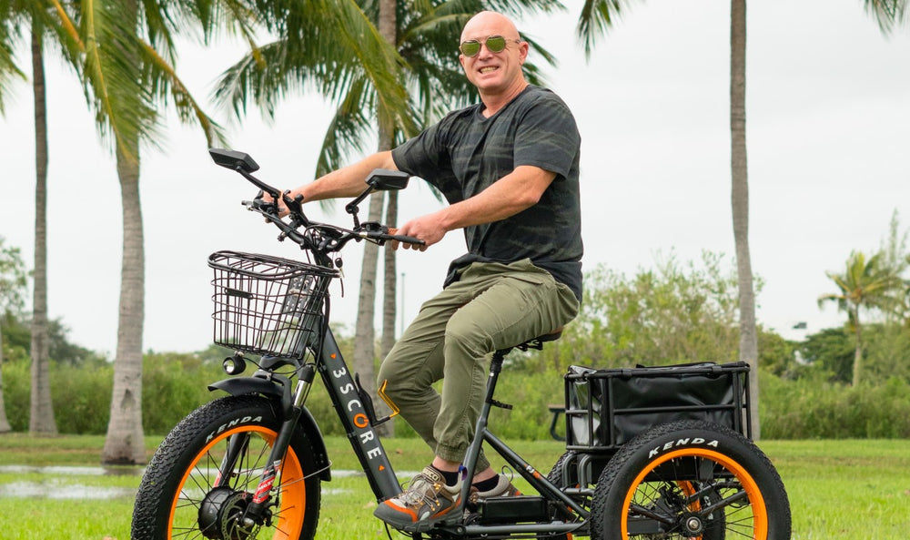 Gray foldable electric trike with man outdoor 750W Motor with 48V Battery: ride in 3 wheels ebike bike for 40+ Miles. With 24 inches fat tires and the extra cushioned seat